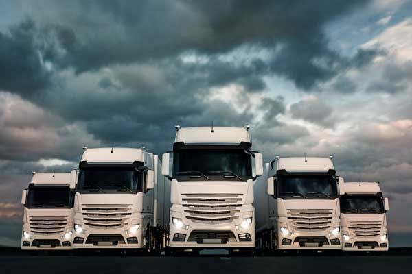 Five semi trucks lined up next to each other imposingly